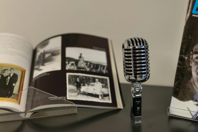 A classic vintage microphone beside an open photo album, nostalgic ambiance.